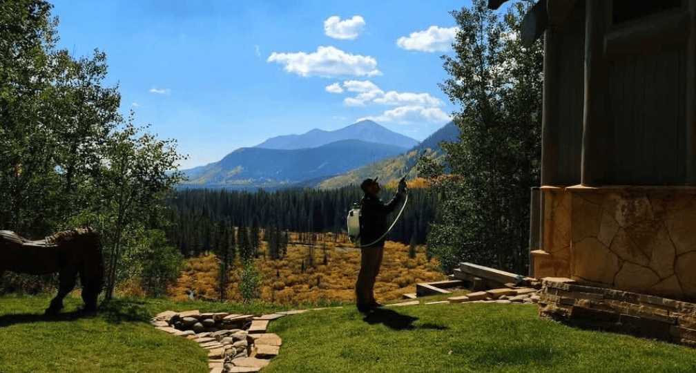Chrome Pest Control spraying a house for pest treatment in Crested Butte, Colorado.
